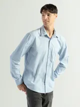 Camisa de manga larga color gris oscuro, confeccionada en algodón, con cuello clásico, cierre frontal con botones, bolsillo de parche en el pecho y corte clásico.