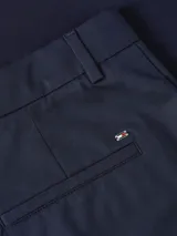 Pantalón chino azul marino de corte slim y pierna recta, con raya marcada en la parte delantera y trasera, cierre oculto de cremallera, dos bolsillos laterales y dos bolsillos traseros de ojal.