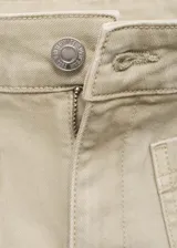 Pantalón tipo jean de tiro medio, corte flare y largo al tobillo. Presenta bolsillos de parche en la parte delantera, cierre frontal con cremallera y botón, y terminación de ruedo desflecado.