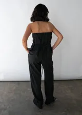 Pantalón de vestir negro, de corte recto y tiro alto, con bolsillos laterales y pretina trasera elastizada.