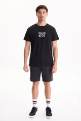 Remera negra de manga corta con estampado de texto blanco en el centro del pecho.