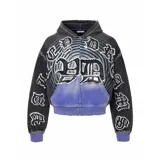 Campera con cierre frontal, de corte boxy fit, color negro con efecto lavado y detalles en violeta. Presenta múltiples parches con tipografía gótica y diseño gráfico circular en el pecho.