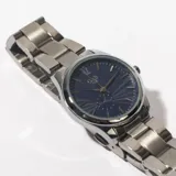 Reloj de pulsera plateado con esfera azul texturizada y agujas plateadas.