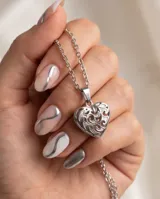 Dije de acero antialérgico con diseño calado en forma de corazón.