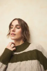 Polera de punto a rayas horizontales color beige y blanco, de manga larga y cuello alto.