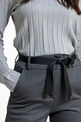 Pantalón de corte recto en color gris, confeccionado en tejido con textura. Presenta cintura elástica con lazo ajustable, bolsillos laterales y dobladillo en los tobillos.