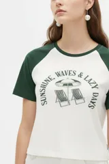 Remera al cuerpo con diseño raglán, color blanco en el torso y azul marino en las mangas cortas y el cuello. Cuenta con un estampado frontal de temática de tenis con las inscripciones "Portofino Tennis" y "Summer Italia".