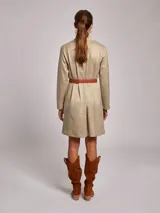 Vestido corto de jersey en color beige, con cuello subido y manga larga. Presenta un corte recto y minimalista.