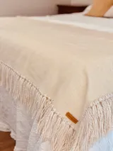 Manta de lana merino color crudo con flecos.