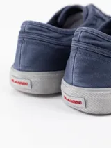 Zapatilla de lona azul marino con lavado especial estilo vintage, puntera de ante y logotipo bordado en rojo en el lateral.