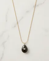Collar de acero con baño de oro y cadena fina, con dije de piedra natural ónix en forma de gota y circonia central color verde oliva.