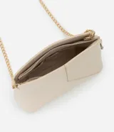 Cartera bandolera pequeña de diseño estructurado en color beige, confeccionada en poliuretano con acabado liso. Presenta un diseño geométrico con costuras en relieve en la parte frontal, cierre superior con cremallera y una elegante correa de cadena metálica en tono dorado.