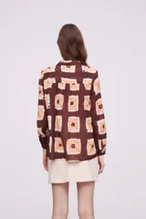 Camisa marrón con estampado de cuadrados color naranja y blanco, de corte holgado y manga larga.
