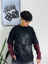 Remera negra de manga larga con efecto doble prenda, combinando manga larga color bordó y remera negra de manga corta con estampa frontal en tono gris y texto "Shhh...".
