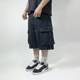 Bermuda negra de jean con corte amplio, bolsillos laterales tipo cargo y largo a la rodilla.