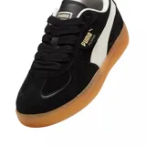 Championes Puma Palermo de gamuza negra con franja lateral blanca y suela de goma color caramelo.