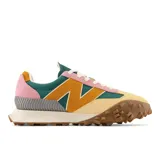 Championes New Balance unisex modelo XC-72, con capellada de gamuza color beige, detalles en verde, naranja y rosa, logo "N" en color naranja, entresuela blanca y suela marrón con diseño de tracción agresivo.