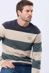 Remera de manga larga con diseño de rayas horizontales anchas en tonos verde, bordó y azul marino. Presenta cuello redondo y una pequeña estampa tipográfica en el pecho.