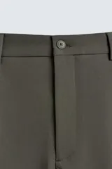 Pantalón de corte relajado en color verde militar, con diseño de pliegues frontales, bolsillos laterales y cierre de cremallera con botón.