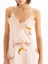 Vestido mini de seda de viscosa con estampa exclusiva de motivos frutales, escote en V con detalle de puntilla, breteles finos y tajo lateral en el ruedo.