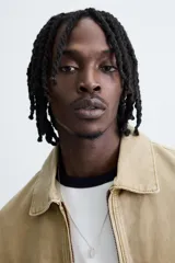 Cazadora de corte relajado confeccionada en tejido de algodón con efecto lavado. Presenta cuello solapa, cierre frontal con cremallera, bolsillos laterales en la cadera y mangas terminadas en puños con botón.