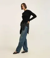 Suéter verde oscuro de punto con cuello alto y mangas largas.