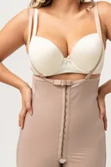 Faja short de lycra color piel, de tiro alto con breteles desmontables, cierre frontal con broches y terminación con encaje en las piernas.