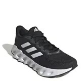 Championes de running Adidas modelo Switch Run, color negro con detalles en blanco. Presentan una parte superior de malla transpirable, entresuela de EVA con diseño de rebajes y suela exterior Adiwear para mayor tracción.