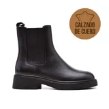 Bota Chelsea de cuero negro con elástico lateral, caña media y suela track.