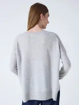 Sweater de cachemira color negro para mujer, con cuello redondo y corte oversized. Presenta costuras externas decorativas, hombros caídos y un diseño ligeramente más largo en la parte trasera con aberturas laterales. Los puños y el bajo cuentan con acabado acanalado.