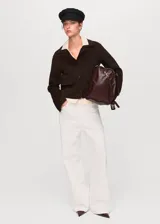 Chaqueta de corte recto confeccionada en mezcla de lana, con cuello camisero, cierre frontal de botones y dos bolsillos de solapa en el frente.