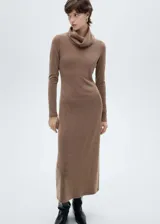 Vestido midi de punto color marrón, con cuello alto vuelto y mangas largas. Presenta un diseño ajustado al cuerpo con caída fluida.