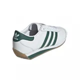 Championes adidas Country II de diseño clásico, color blanco con las icónicas tres tiras laterales y detalles en el talón en color verde. Presentan suela de goma color caramelo y entresuela blanca con una franja verde.