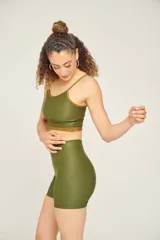 Top tankini color ladrillo con breteles finos ajustables y contorno en color crema.