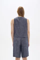 Chaleco azul sin mangas con cuello en V y cierre frontal con botones.