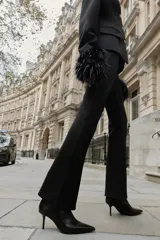 Leggings negros de tiro alto con costura marcada en el frente y bajo acampanado (flare). Cierre frontal con cremallera, botón interior y gancho.