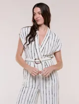 Enterito largo ABS Allen Schwartz de calce fluido, color blanco con diseño de rayas verticales negras. Presenta escote en V cruzado, mangas cortas, cintura definida con cinturón y hebilla ovalada, pantalón wide leg con bolsillos laterales y pinzas.