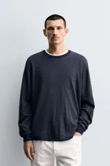 Jersey de punto con diseño de rayas horizontales finas, cuello redondo y manga larga. Presenta un corte regular fit con terminaciones en rib en cuello, puños y ruedo.