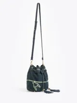 Bandolera tipo bucket bag confeccionada en gamuza color verde oscuro con bordados decorativos en hilo claro. Presenta cierre de cordón ajustable con borlas en los extremos, correa larga regulable de cuero y detalles metálicos dorados.