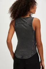 Musculosa de algodón acanalado color blanco off-white, de calce ajustado, con escote redondo, ruedo curvo y tiras con hebillas metálicas decorativas en los hombros.