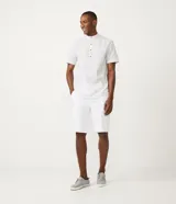 Bermuda masculina de sarga en color blanco, con corte slim, cierre de botón y cremallera, y bolsillos laterales.