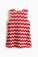 Top sin mangas de punto jacquard estilo crochet con patrón en zigzag de franjas rojas y blancas, cuello redondo y bajo levemente acampanado.