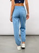 Pantalón de piqué recto color azul marino, con cintura elástica y cordón ajustable. Presenta el escudo del Club Nacional de Football en el muslo izquierdo y el logo de Umbro en el muslo derecho.