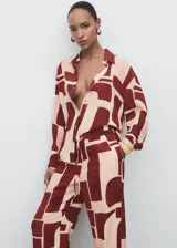 Pantalón fluido de tiro medio con estampado geométrico en tonos bordó y beige, cintura elástica con cordón ajustable, bolsillos laterales y diseño de pernera recta.