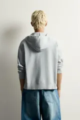 Sudadera hoodie relaxed fit de punto color gris, confeccionada en hilatura con viscosa de tacto suave, con cuello con capucha ajustable, manga larga, cierre frontal con cremallera y acabados en rib.