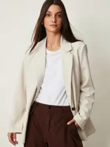 Blazer beige claro de corte recto, con solapas de muesca, mangas largas y bolsillos frontales.