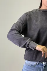 Buzo de cuello redondo con efecto acid wash, de corte holgado y mangas largas con puños elásticos.