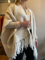 Ruana color crema tejida en telar liso con flecos.