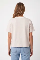 Remera básica de corte holgado, color beige melange, de manga corta y cuello redondo acanalado.