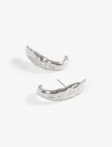 Aros pasantes plateados de acero quirúrgico, con forma curva y textura martillada o machacada.